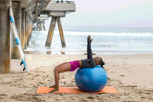 woman doing Russian Twist exercise on a Swiss ball on the beach