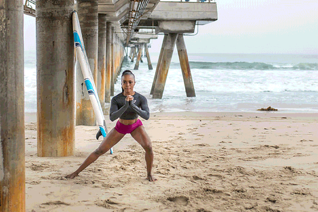 woman doing Skater to Curtsy Squat exercise on the beach