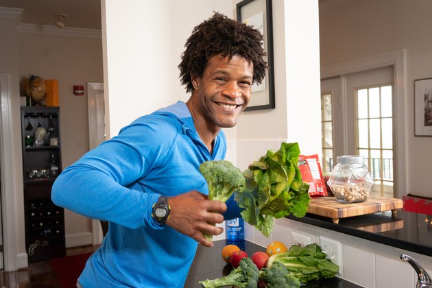 Errick holds broccoli and lettuce.