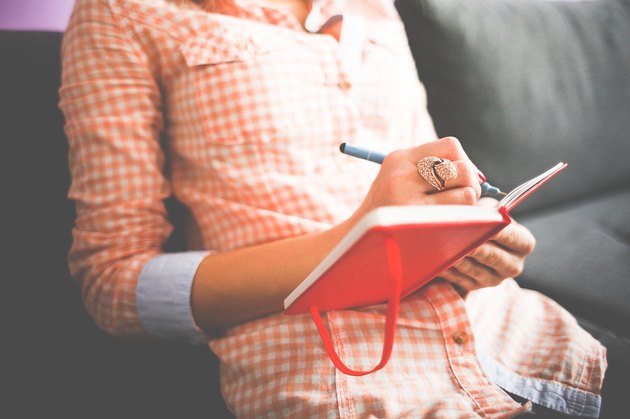 woman writing in a food journal