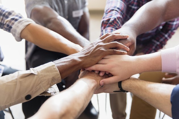 People in a Weight Watchers support group joining their hands together