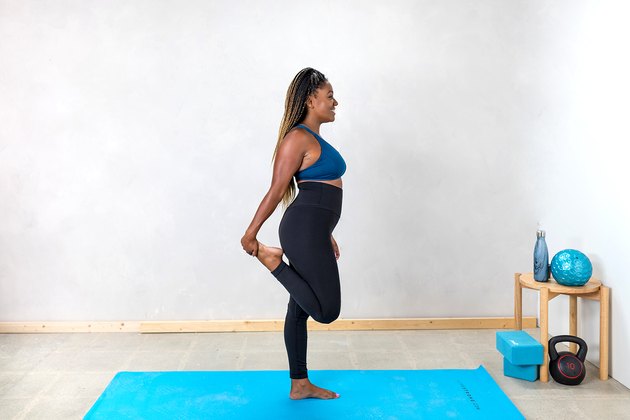 woman doing a standing quad stretch