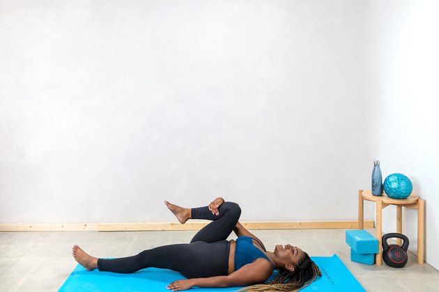 woman doing a supine knee-to-chest stretch
