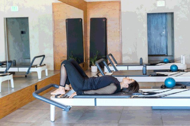 woman doing Shoulder Bridge on a Pilates reformer