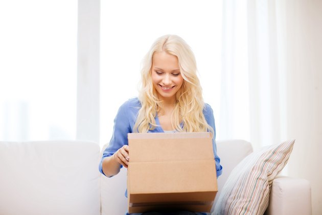 woman opening package containing monthly subscription box