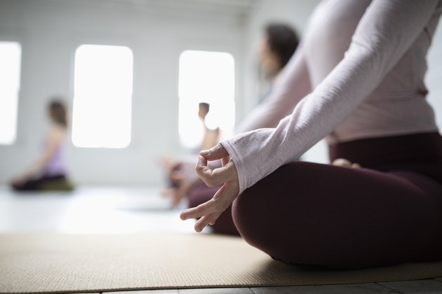 关闭妇女实践的莲花定位凝思用手在瑜伽类的吉安mudra