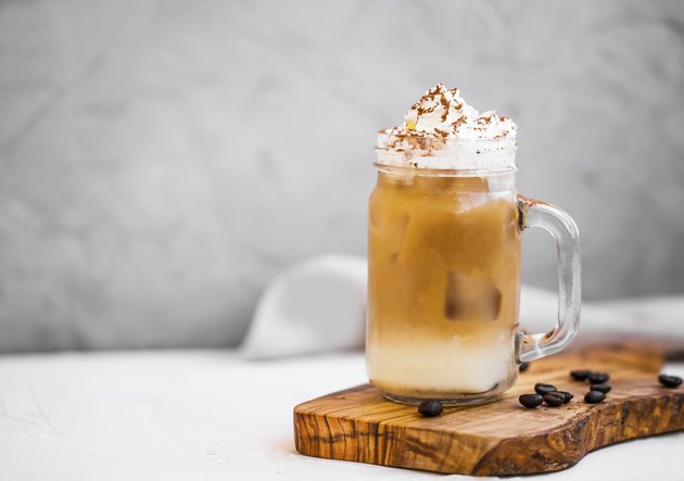 Ice coffee cup with cream. Ice frappuccino summer refreshing coffee drink with cream