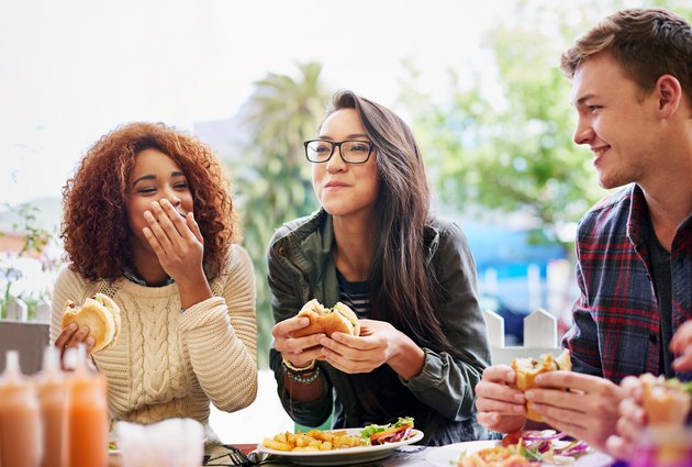 Friends eating burgers and trying to figure out how to stop overeating