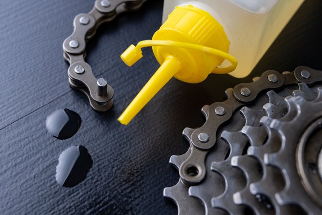 A gear and chain on a workshop table. Oiling and repair of bicycle drive. Dark background.