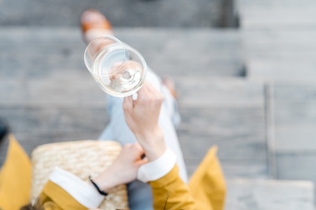 Overhead view of a woman with a glass of white wine