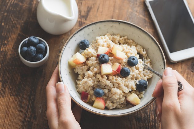 Top view of a person eating oatmeal for breakfast to boost metabolism
