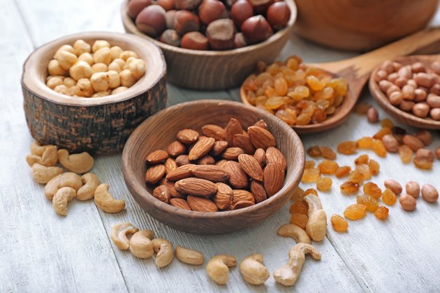 Different kinds of nuts and raisins on table