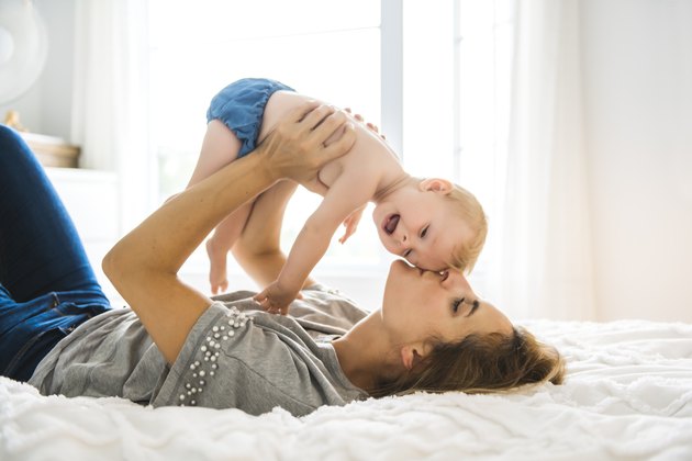 Mother and baby girl on bed