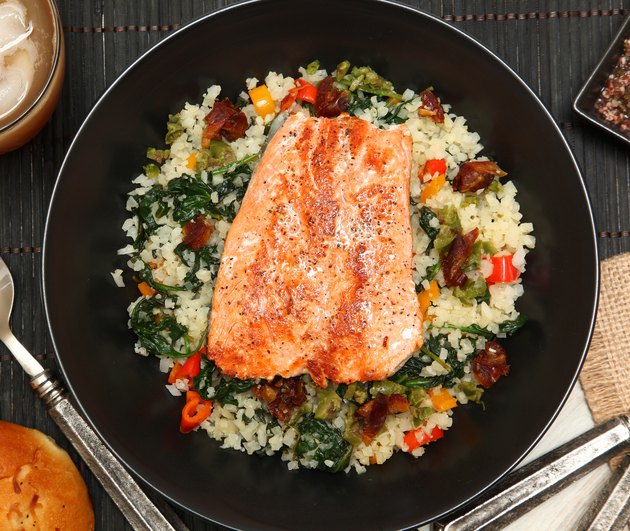 Top view of a bowl of salmon over riced cauliflower