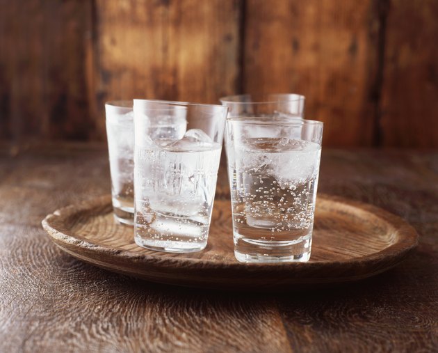 苏打水在玻璃杯上的老式木制板冰