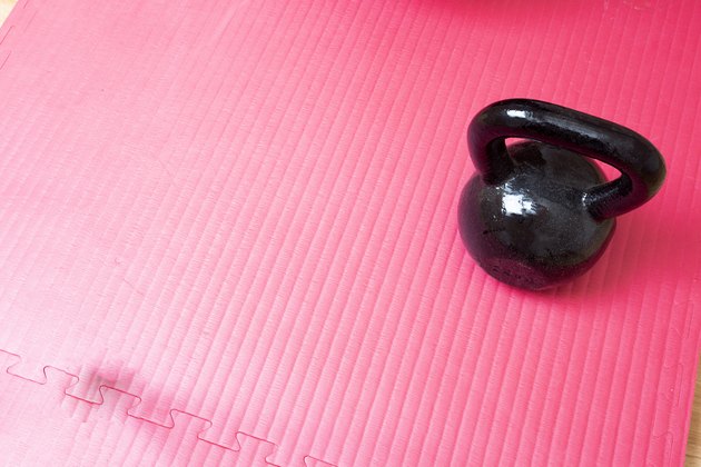 Kettlebell and pink yoga mat on the floor for a high-intensity workout for weight loss