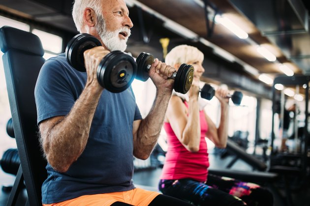 Fit senior man and woman doing exercises in the gym to combat belly fat and weight gain
