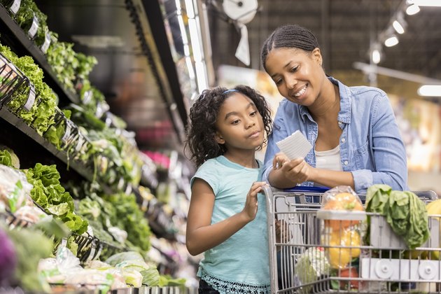 Mother and daughter grocery shop together using list