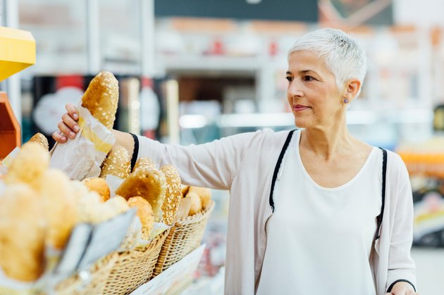 Mature Woman Groceries Shopping for foods for gluten free symbol