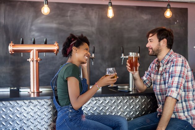 Couple talking and drinking beer in a bar