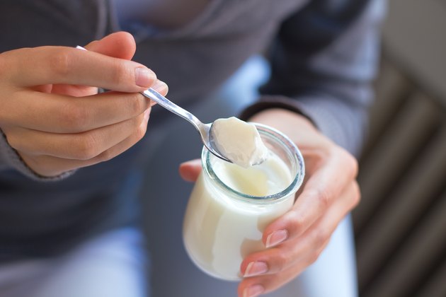 Eine Frau, die Joghurt als natürliches Heilmittel gegen Verstopfung isst