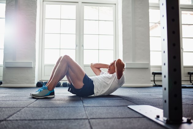 man doing sit-ups ab workout in a gym
