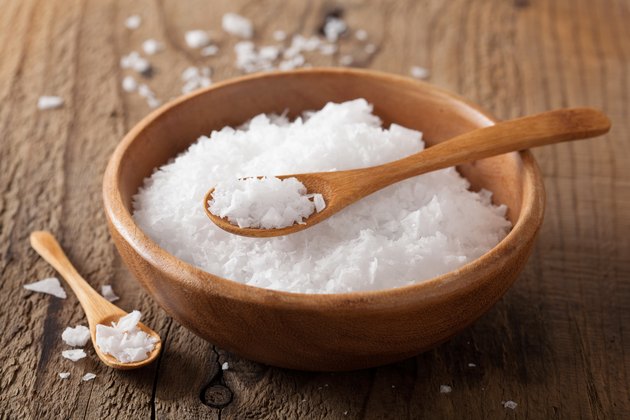 Sea salt and spoons in wooden bowl