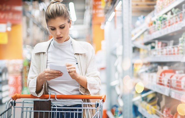 Woman checking her list while shopping in a supermarket