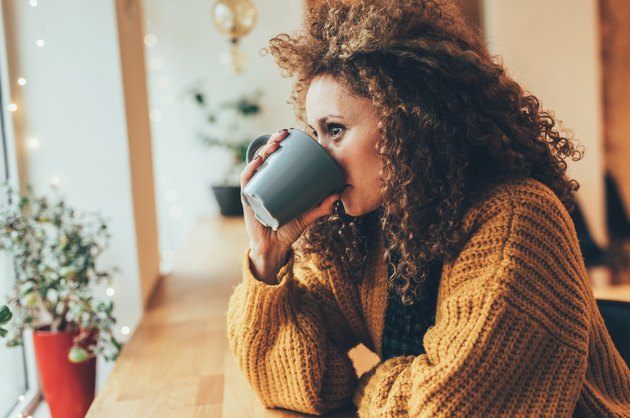 A woman drinking a cup of coffee in a cafe