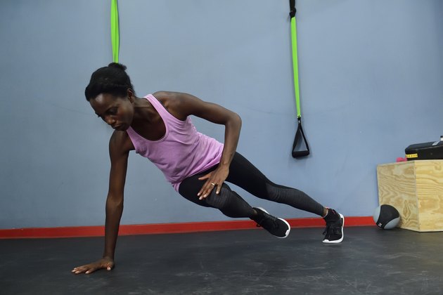 Woman practicing in a gym doing a side plank