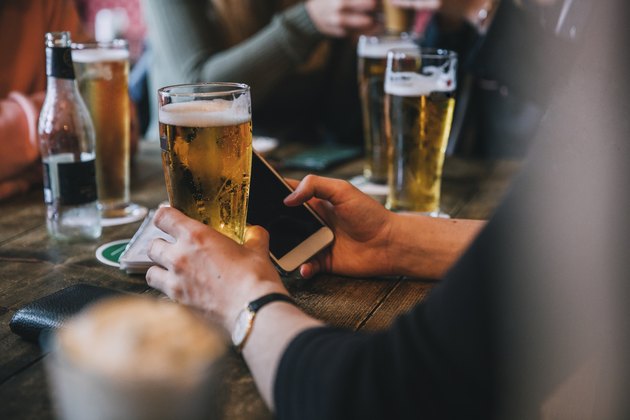 A group of friends drinking pints of beer at a bar