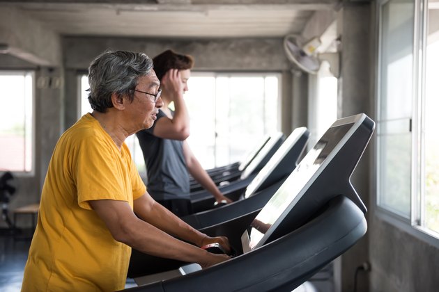 老年人在跑步机上为初学者做有氧运动