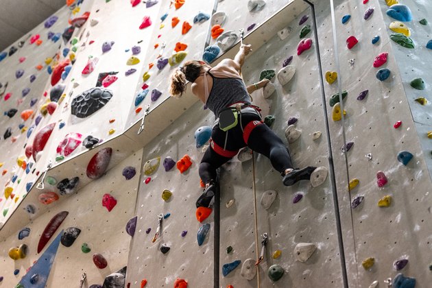 Woman climbing an indoor rock climbing wall