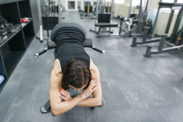 Young beautiful athletic woman brunette doing fitness exercises in the gym. Fitness, sport, training, people, healthy lifestyle concept.