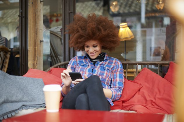Woman at coffee shop using mobile phone