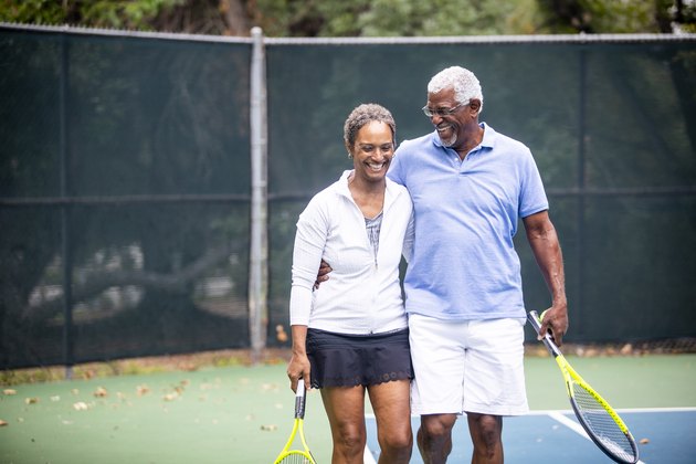 一对年长的黑人夫妇在网球场上