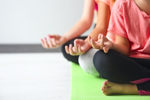Young woman having fun with kids doing yoga. Family sport concept