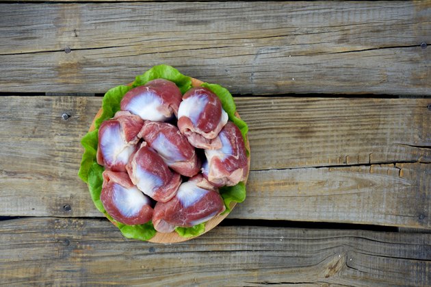 Raw Chicken gizzards on wood background