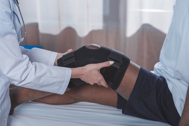 doctor putting on knee brace