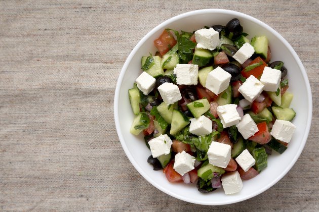 Homemade Shepards salad with cucumbers, feta and parsley in a white bowl, top view. From above, overhead. Space for text.