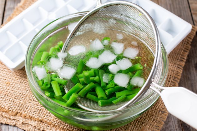Boiled vegetables, green beans in ice water after blanching