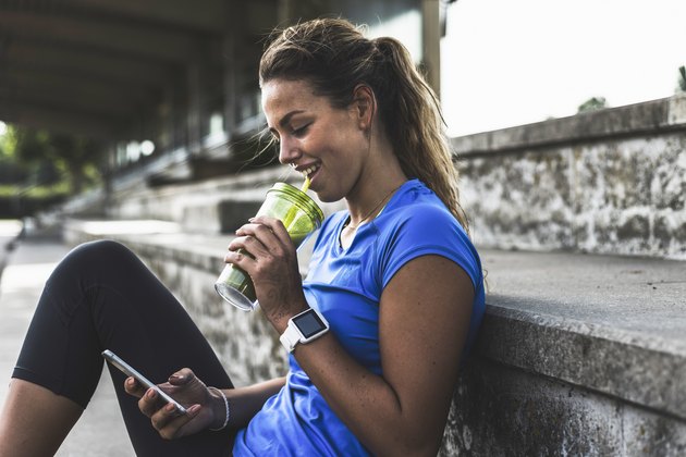 A young woman drinking a smoothie after a workout