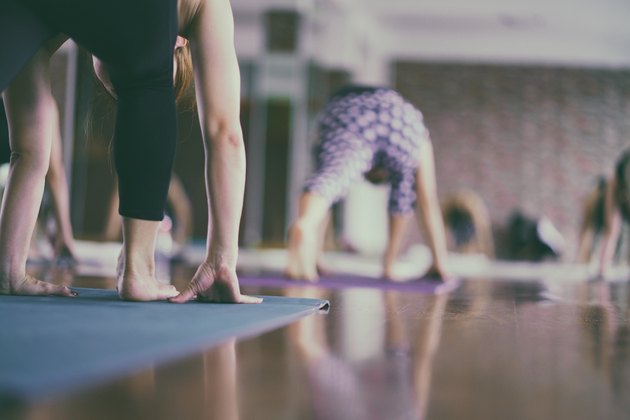 Group of young woman stretching and practicing during their yoga class