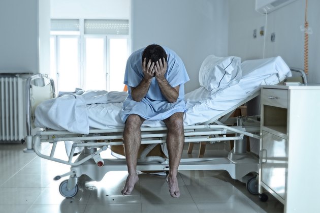 desperate sick man at hospital bed alone sad and depressed