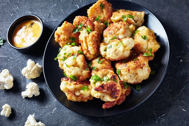 Fried in batter Cauliflower florets served on a black plate