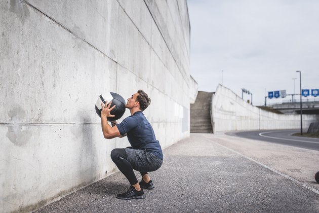 演示如何在Crossfit锻炼期间做墙球的人