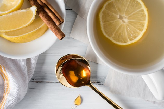 High Angle View Of Honey With Lemons On Table