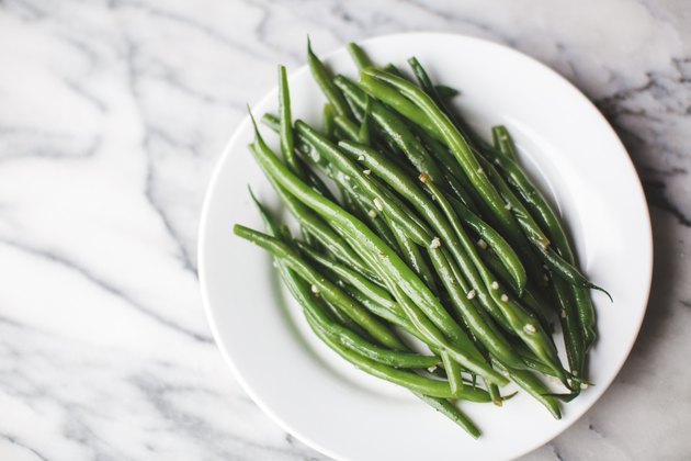 Cooked green beans on a white plate