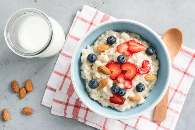 Oatmeal porridge with fresh berries and nuts, top view