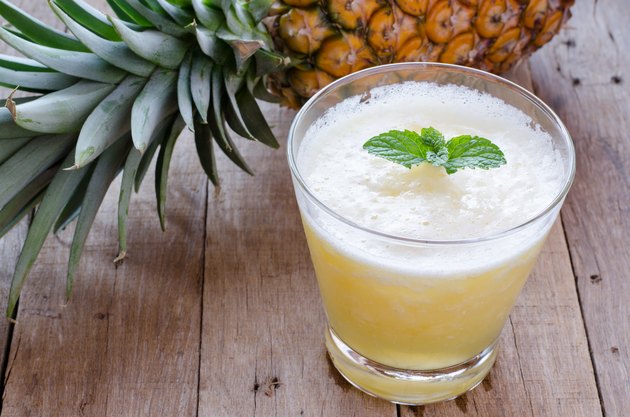 Glass of pineapple juice on wooden table